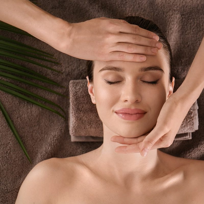 Beautiful young woman enjoying massage in spa salon, top view